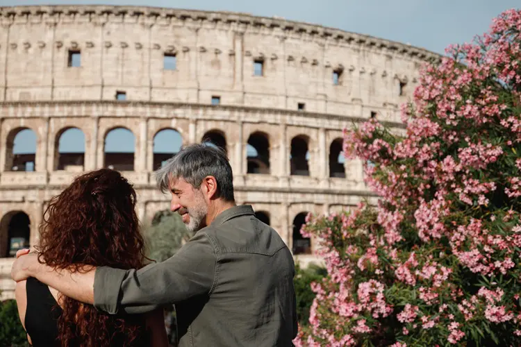Casal de recém casados visitando o Coliseu, em Roma.