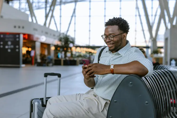 Homem acessando a internet no celular com o melhor chip internacional.