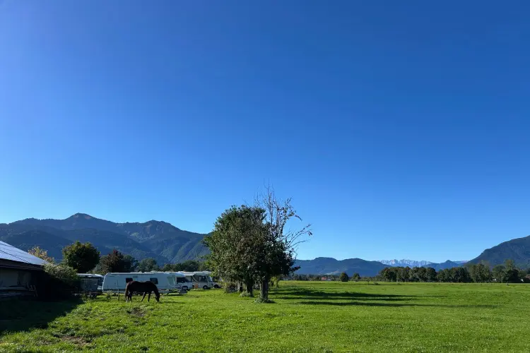 Paisagem bucólica com animais e montanhas no camping localizado em uma fazenda, no maior lago da Baviera ilustra mais uma possibilidade ao viajar com trailer na Europa