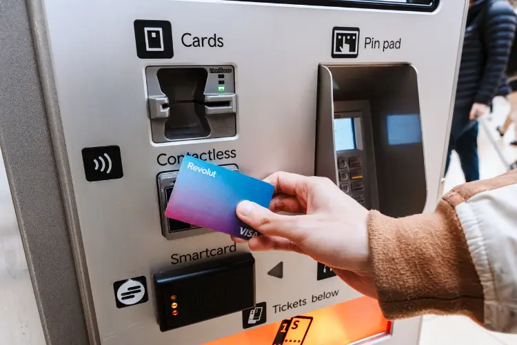 Turista utiliza cartão Revolut para fazer saque em caixa eletrônico.
