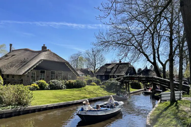Canal de Giethoorn com casas tradicionais, barcos e pontes de madeira.
