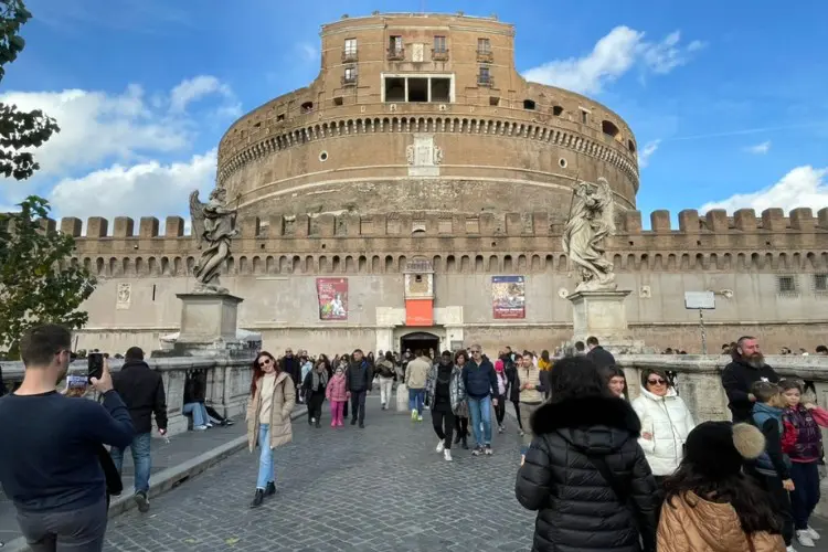 Turistas caminham em frente ao Castelo de Santo Ângelo em Roma.