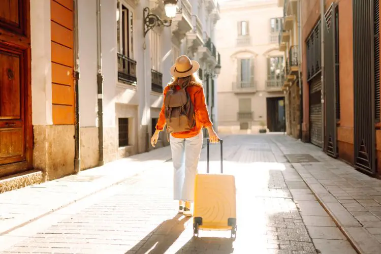 Mulher andando com sua mala pela Europa em junho.